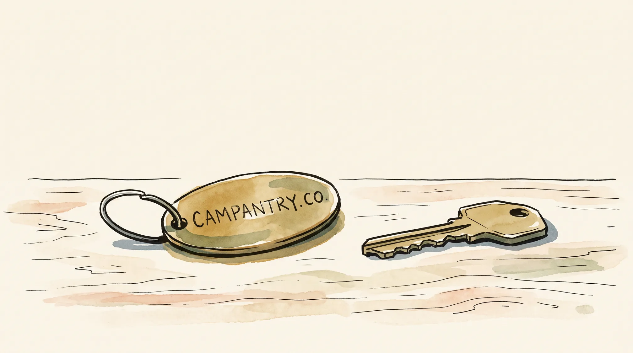An oval brass keyring fob engraved CAMPANTRY.CO lies on a wooden counter next to a newly cut brass key.