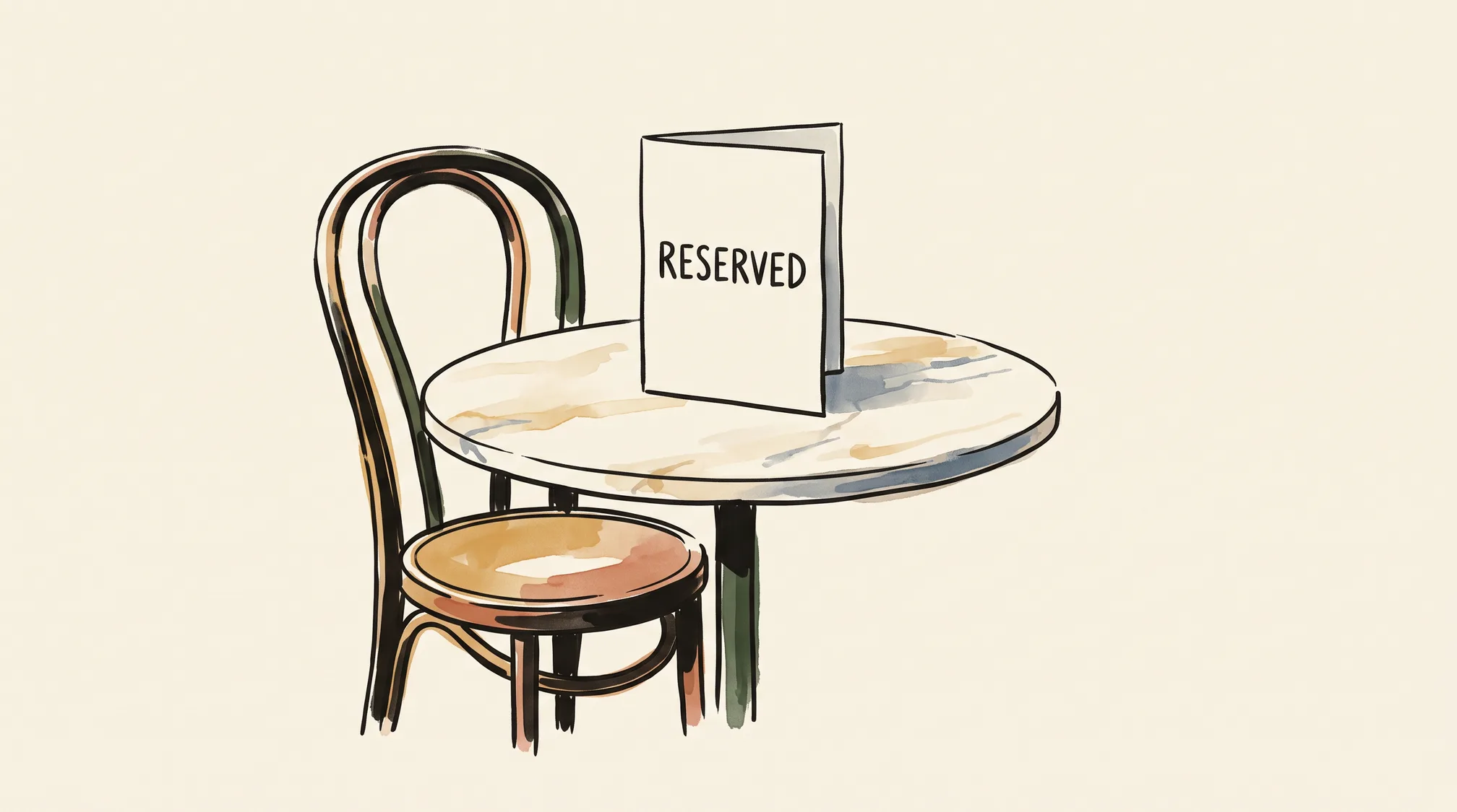 A folded card reading RESERVED stands on a small round café table with an empty chair beside it.